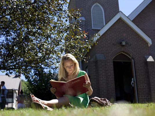 Woman reading outside church